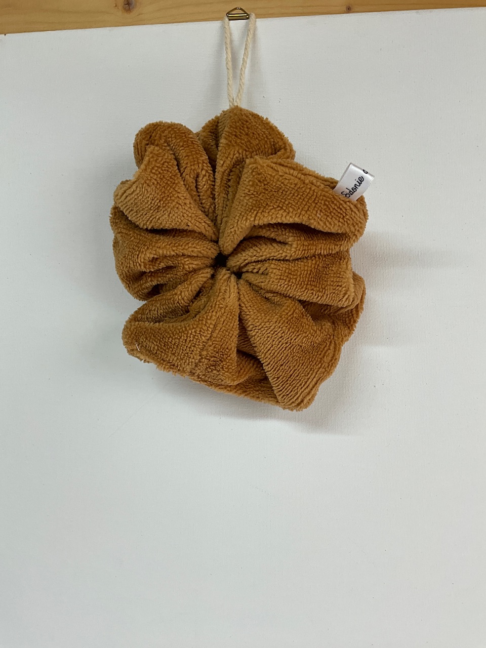 Éponge de douche lavable adulte coloris camel suspendue par son cordon de coton pour sécher entre deux douches