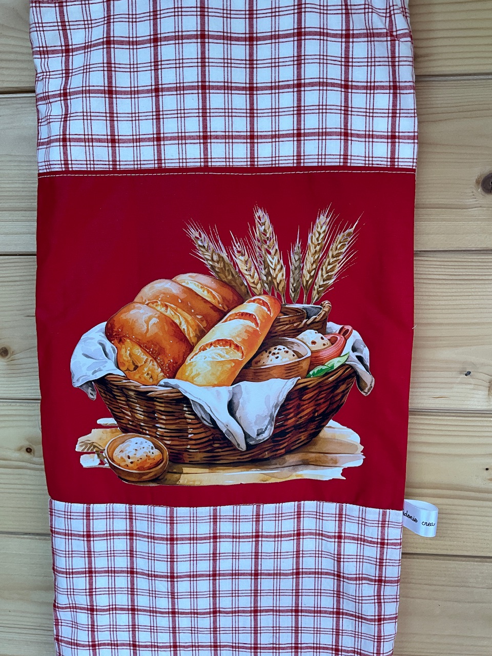 Gros plan du flocage corbeille de pain et épis de blé sur le sac à pain motif carreaux rouges fond blanc, cousu main Sidonie Créa