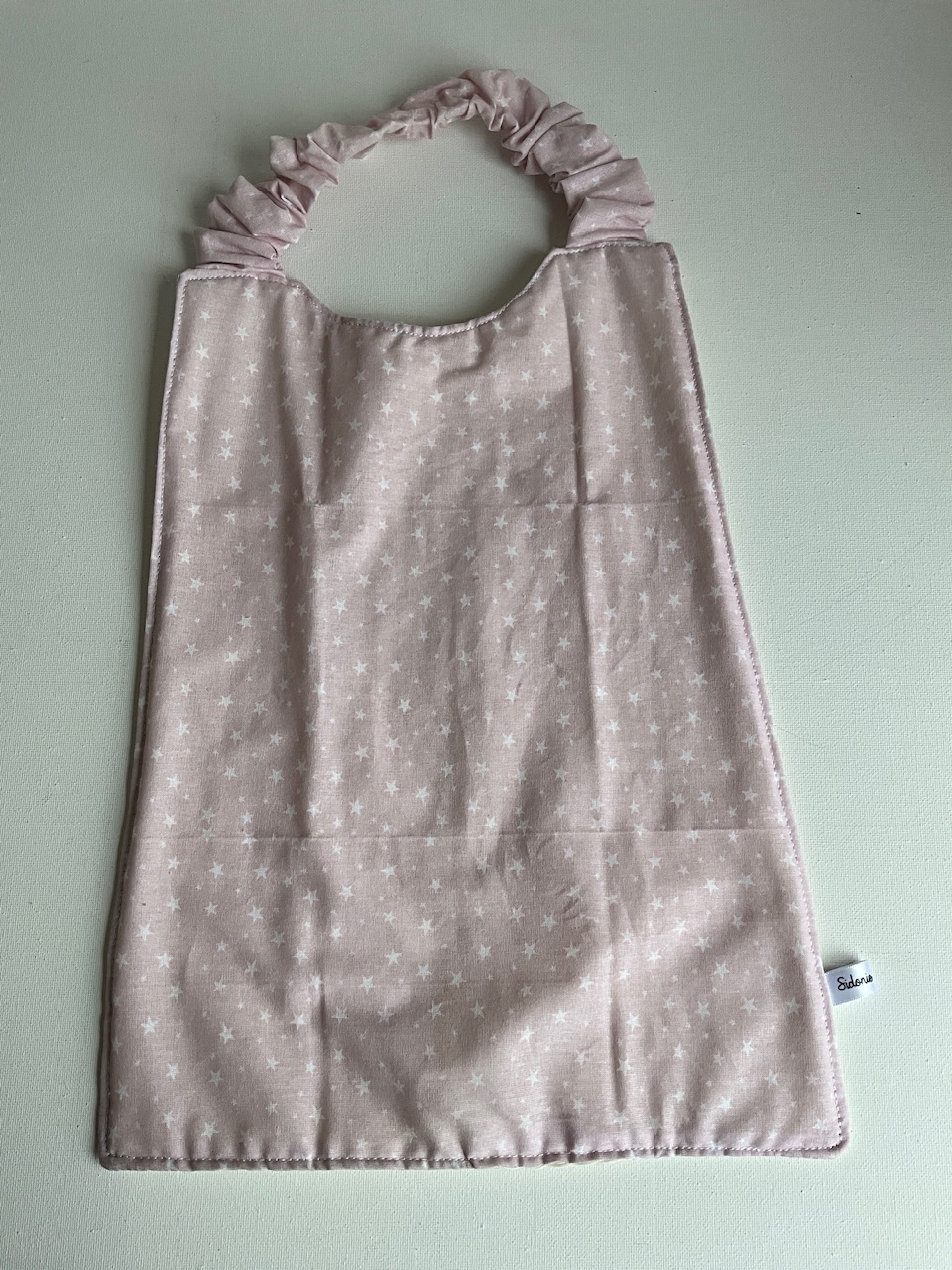 Serviette de cantine enfant dès 3 ans à encolure élastiquée, motif Étoiles rose poudré, coton imprimé et nid d'abeille